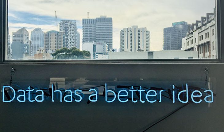 View from an office building looking out over a cityscape with neon blue sign "Data has a better idea".
